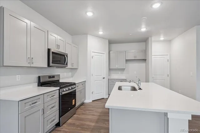 a kitchen with a sink a stove and cabinets