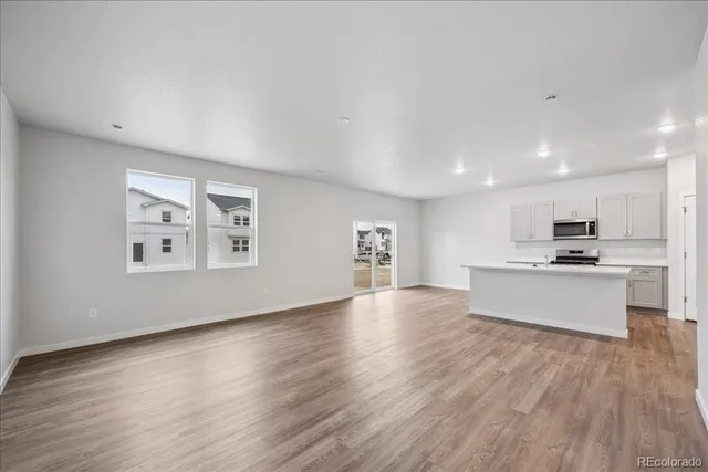 a view of kitchen with microwave a stove and wooden floor