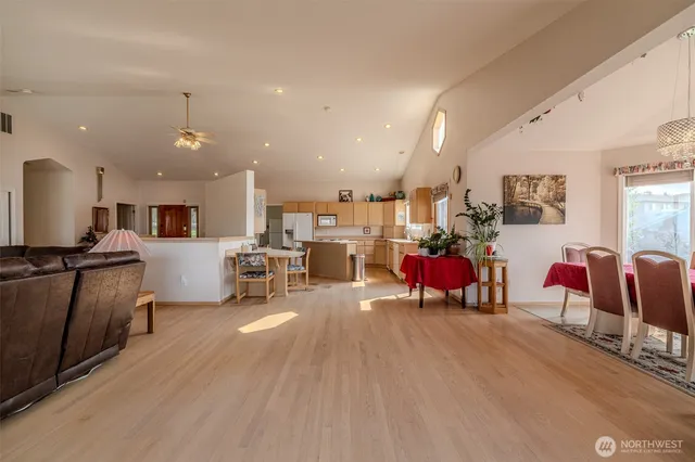 a living room with furniture a wooden floor and kitchen view