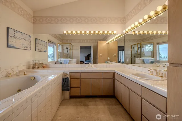 a en suite bathroom with a tub and large windows