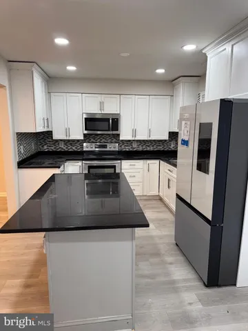a bathroom with a granite countertop toilet a sink and a shower