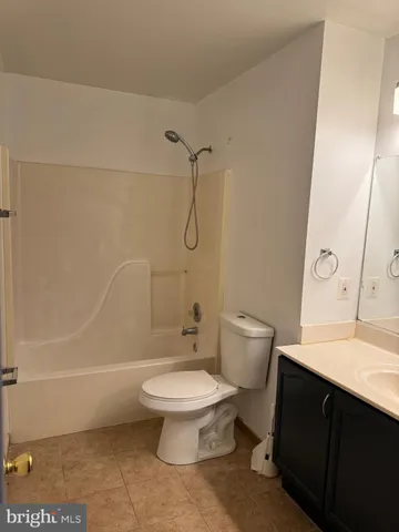 a bathroom with a granite countertop toilet sink and a mirror
