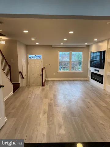 a view of empty room with wooden floor and windows