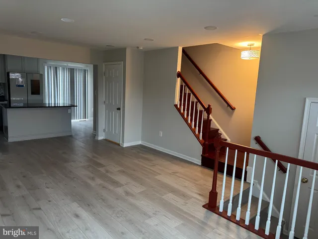 a view of a hallway with wooden floor and stairs