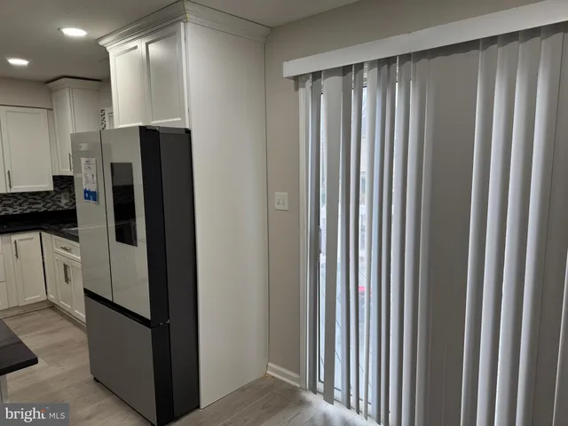 a view of an empty room with window and stairs