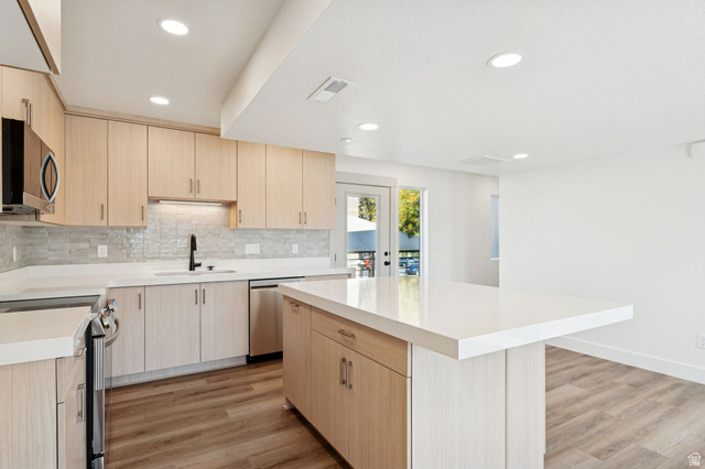 252 North Main Street Bountiful, UT 84010 - Photo 7 of 34 Kitchen with light wood finish cabinetry, a kitchen island, light wood-style floors, stainless steel appliances, and recessed lighting