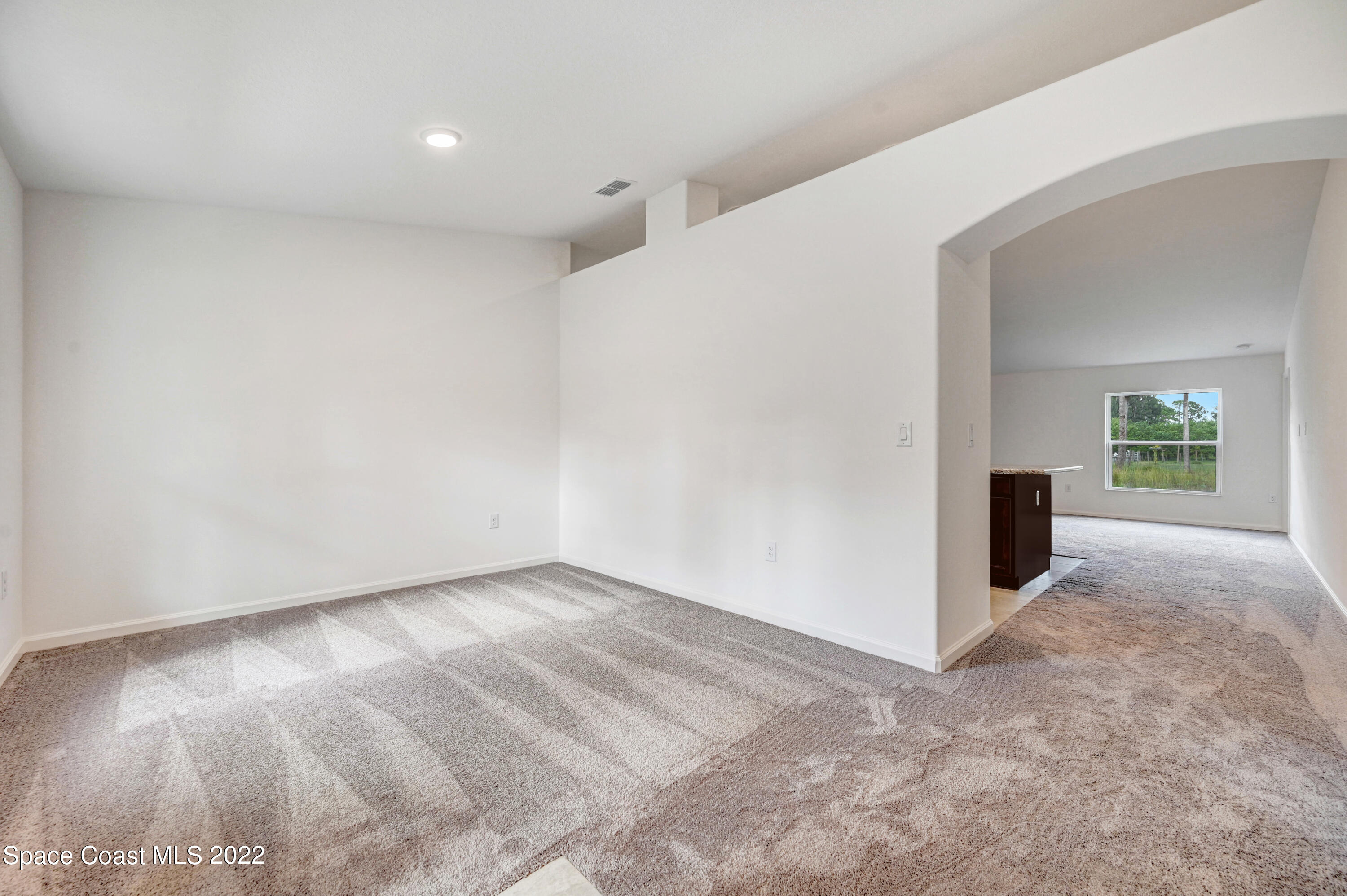 561 Scenic Road Palm Bay, FL 32908 - Photo 12 of 40 a view of a livingroom with wooden floor and a ceiling fan