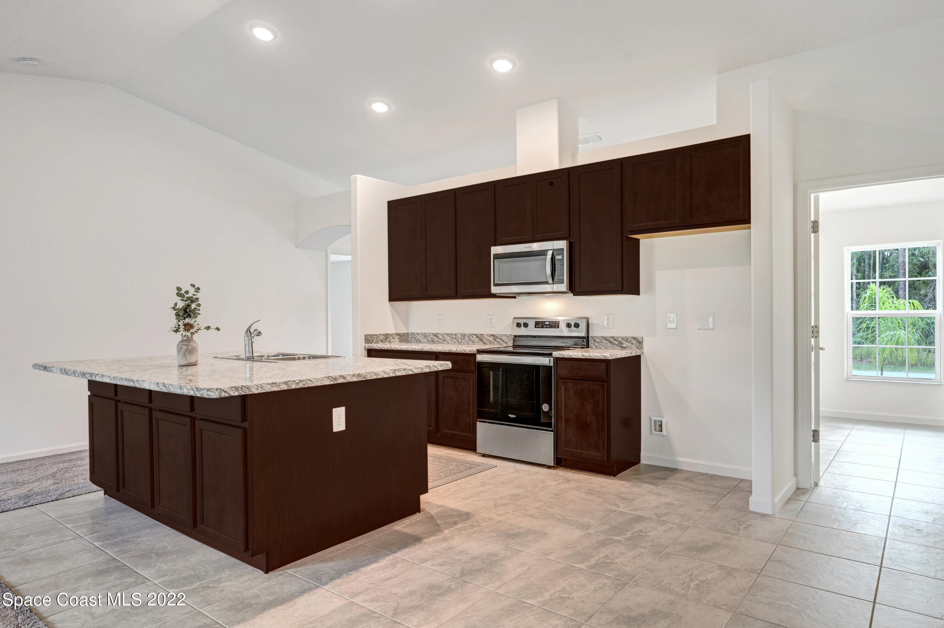 561 Scenic Road Palm Bay, FL 32908 - Photo 18 of 40 a kitchen with stainless steel appliances a sink stove and refrigerator
