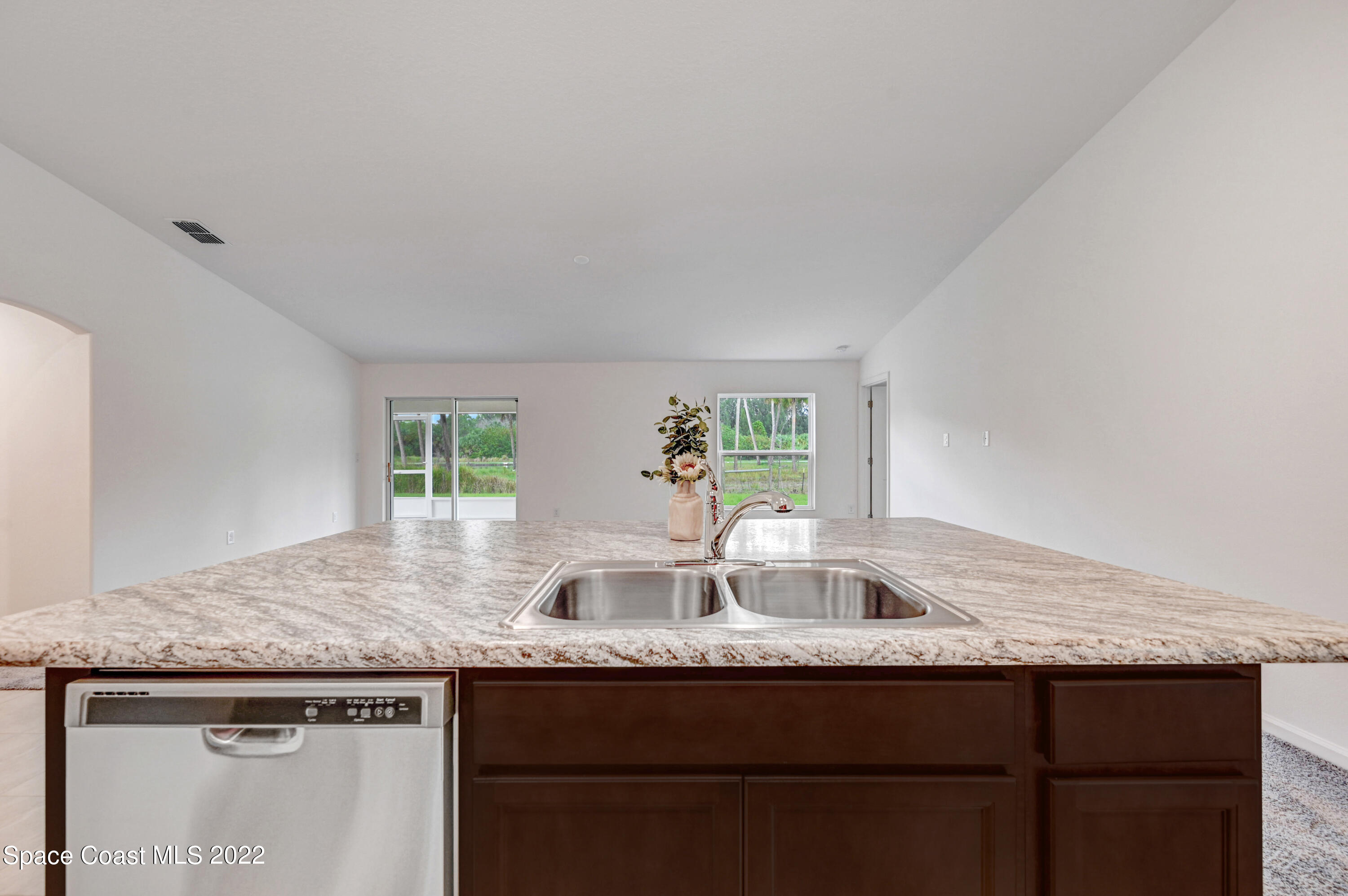 561 Scenic Road Palm Bay, FL 32908 - Photo 23 of 40 a kitchen with granite countertop kitchen island a sink and a wooden cabinets