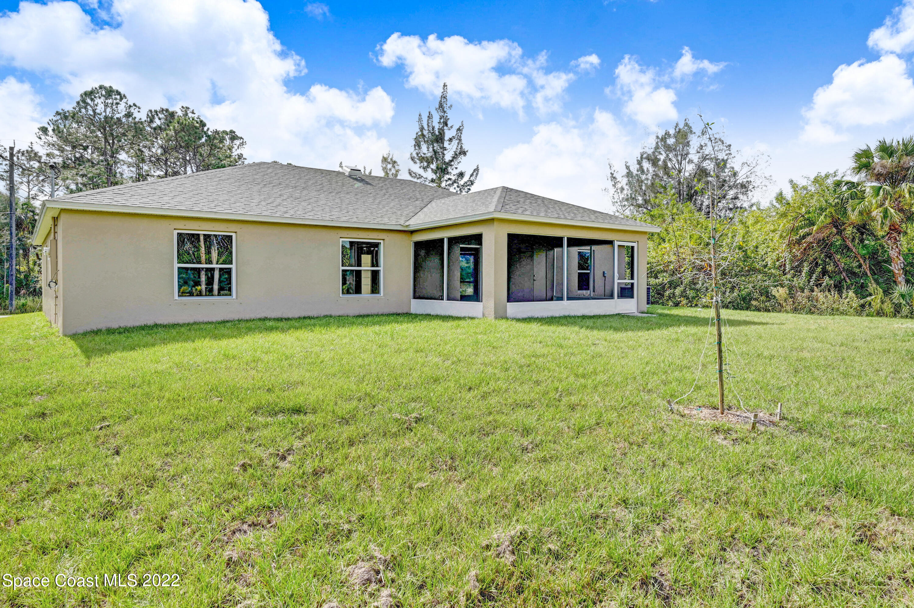 561 Scenic Road Palm Bay, FL 32908 - Photo 6 of 40 a big house with a big yard and potted plants in front of it