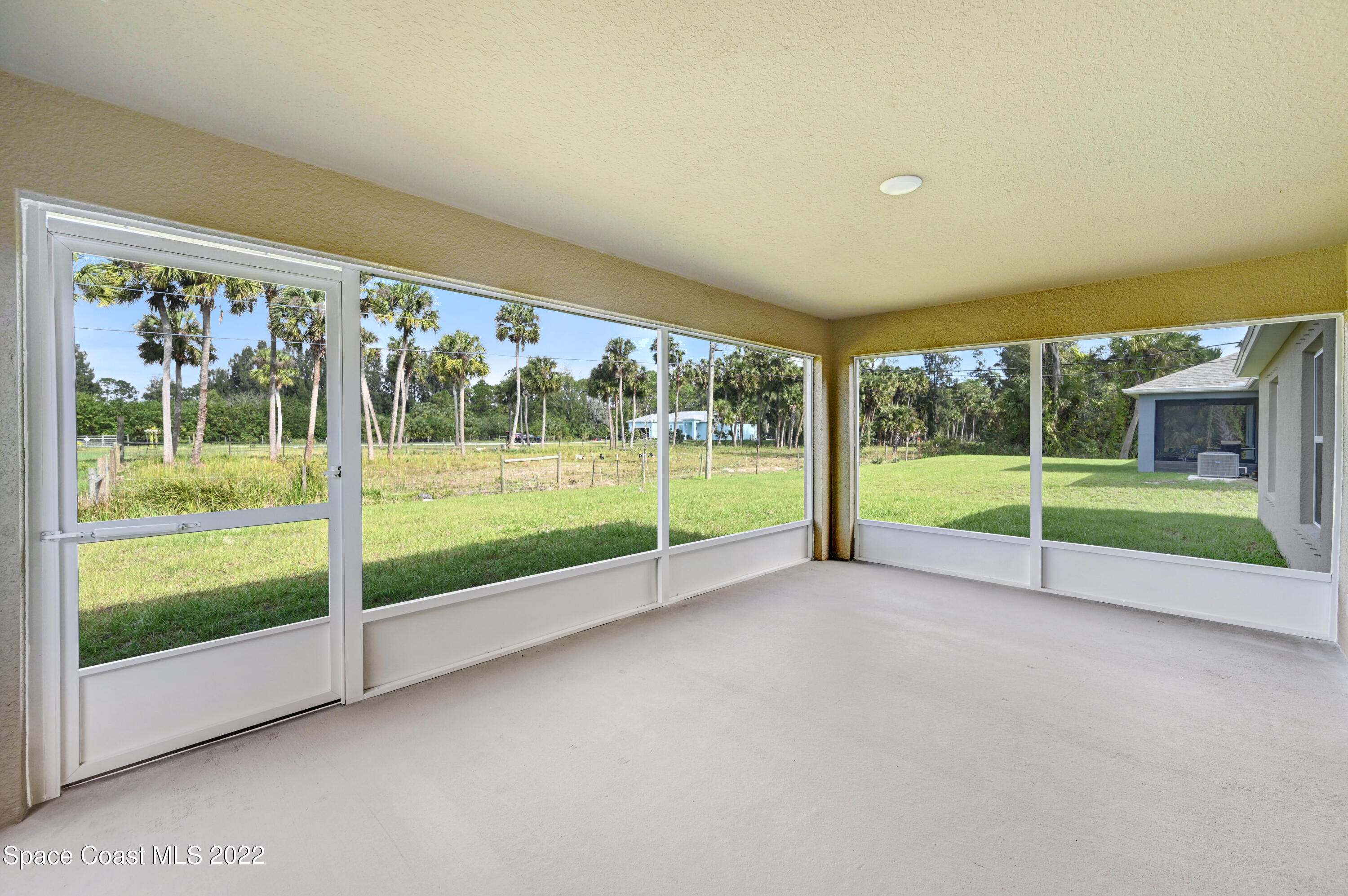 561 Scenic Road Palm Bay, FL 32908 - Photo 9 of 40 a view of a house with a big yard and large trees