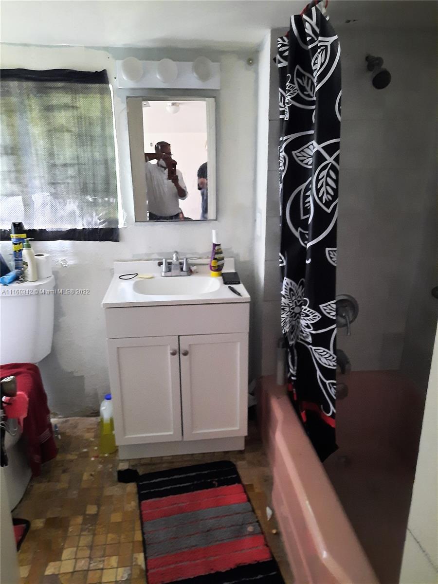 1084 South Ridge Road Lake Worth, FL 33462 - Photo 8 of 13 a bathroom with a sink and a mirror