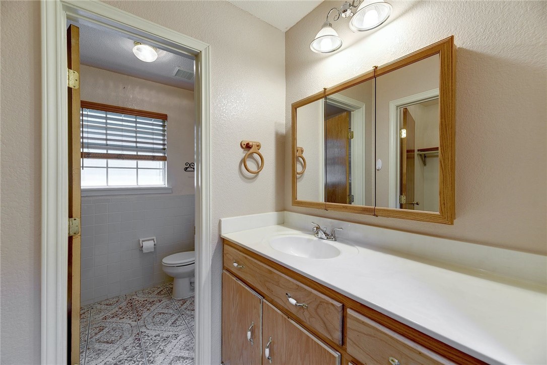 6402 Santos Street Austin, TX 78741 - Photo 16 of 22 a bathroom with a sink a toilet and a mirror