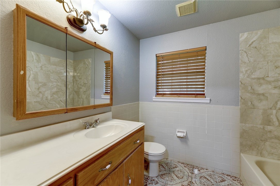 6402 Santos Street Austin, TX 78741 - Photo 19 of 22 a bathroom with a sink a toilet and mirror
