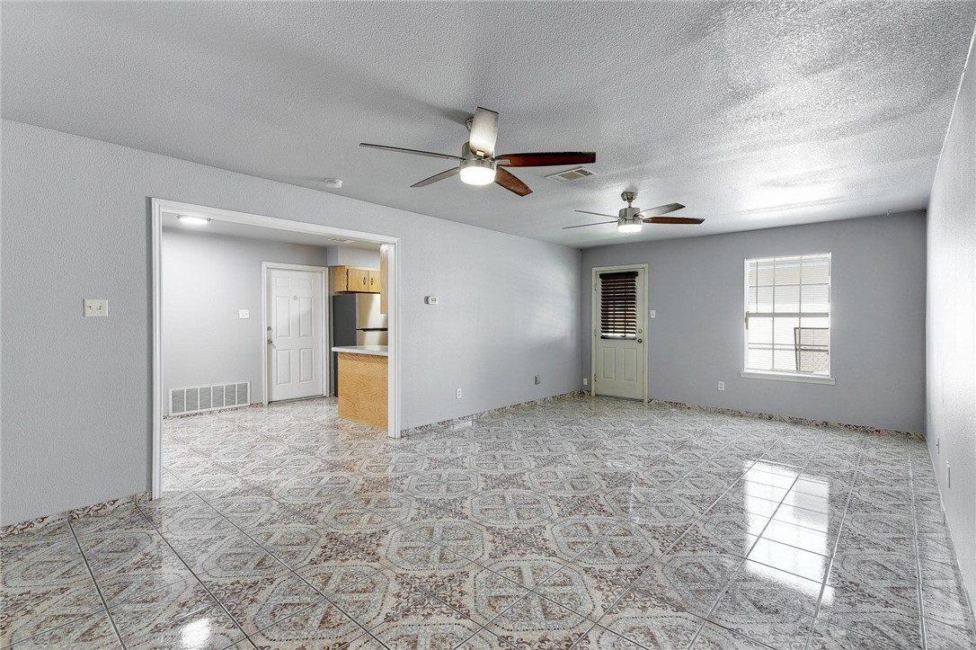 6402 Santos Street Austin, TX 78741 - Photo 3 of 22 a view of a big room with windows and chandelier fan