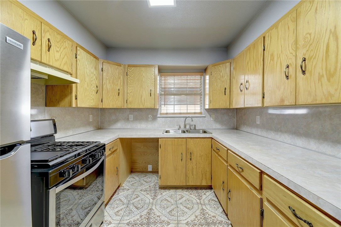 6402 Santos Street Austin, TX 78741 - Photo 4 of 22 a kitchen with stainless steel appliances granite countertop a sink a stove and a microwave