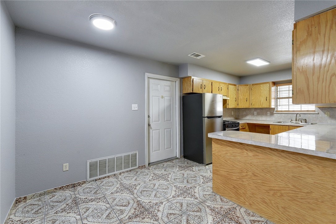 6402 Santos Street Austin, TX 78741 - Photo 8 of 22 a kitchen with stainless steel appliances granite countertop a refrigerator and a sink