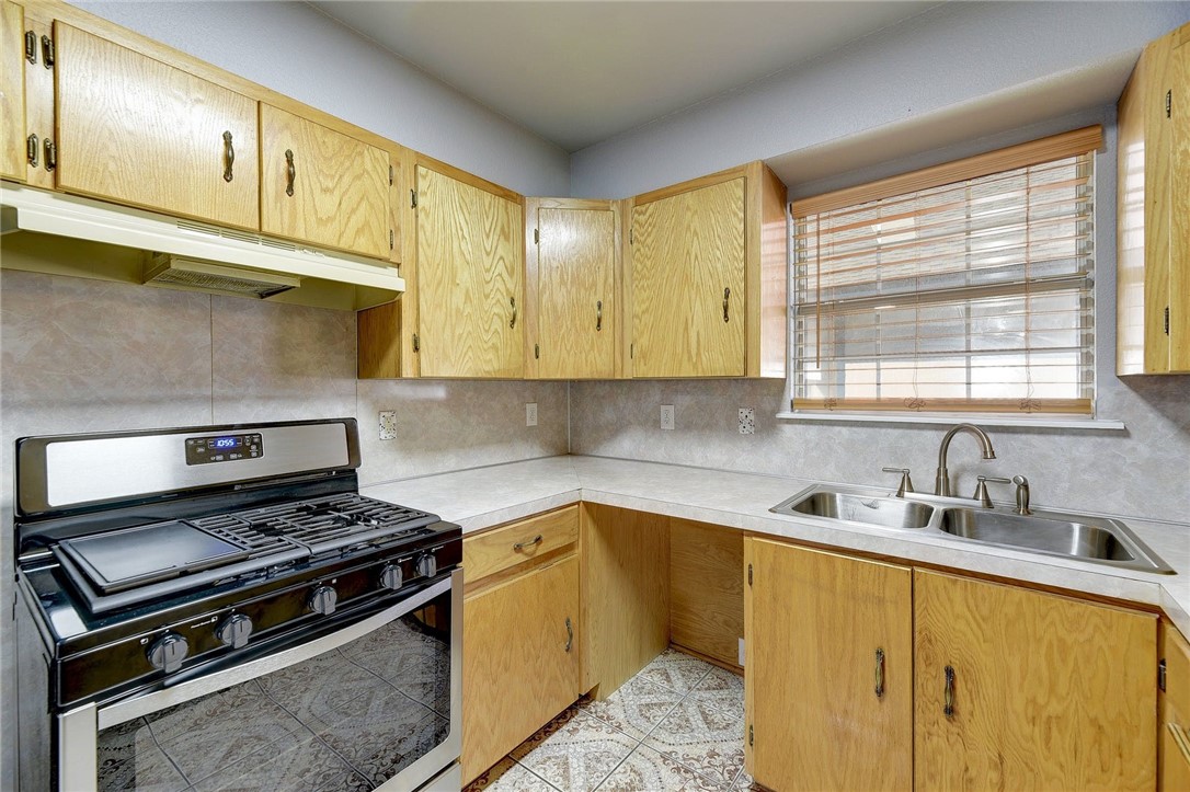 6402 Santos Street Austin, TX 78741 - Photo 9 of 22 a kitchen with a stove a sink and a microwave