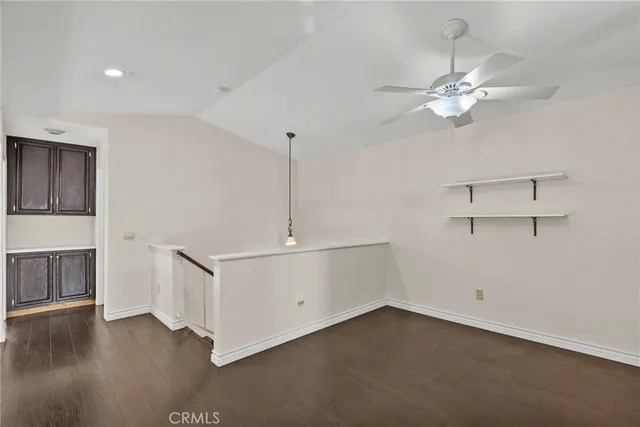 a view of an empty room with wooden floor and a fireplace
