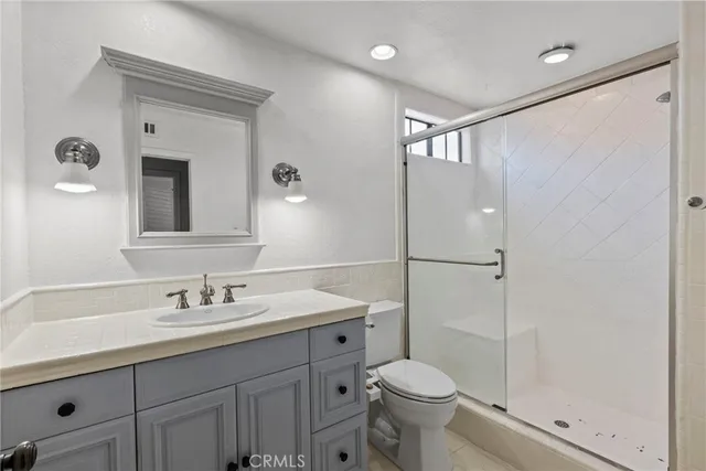 a bathroom with a sink a toilet and shower