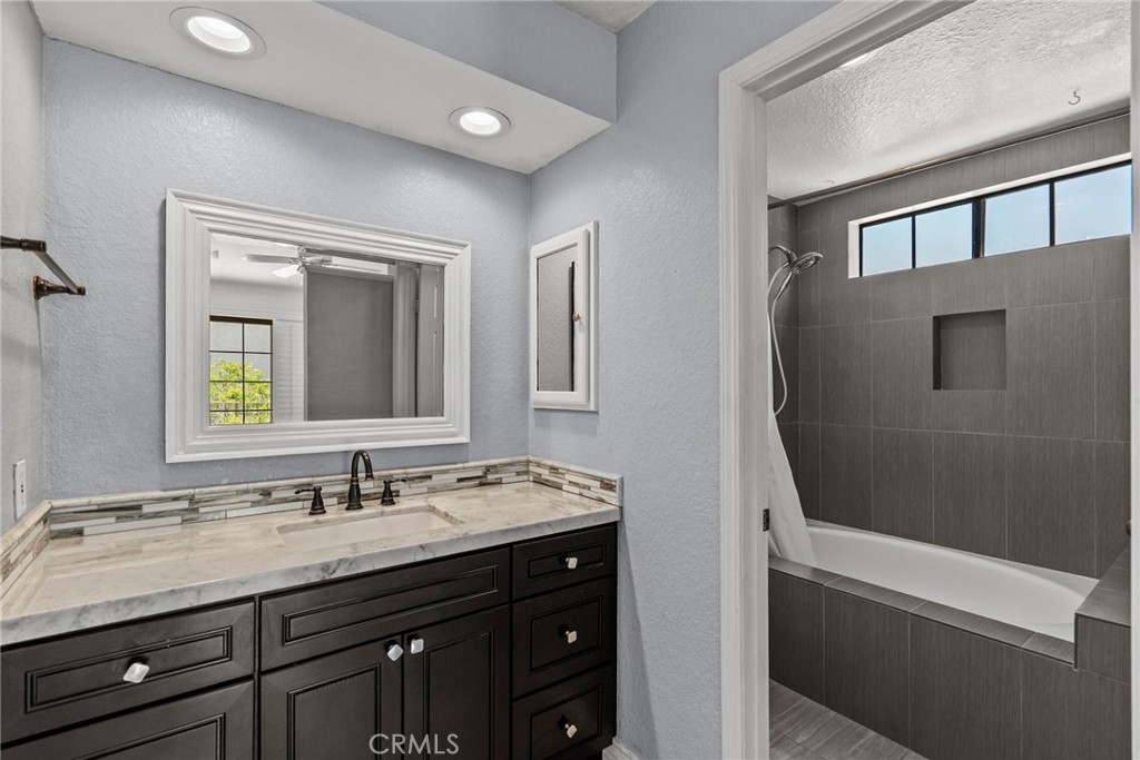 808 Links View Drive Simi Valley, CA 93065 - Photo 25 of 28 a bathroom with a granite countertop sink a mirror and a shower