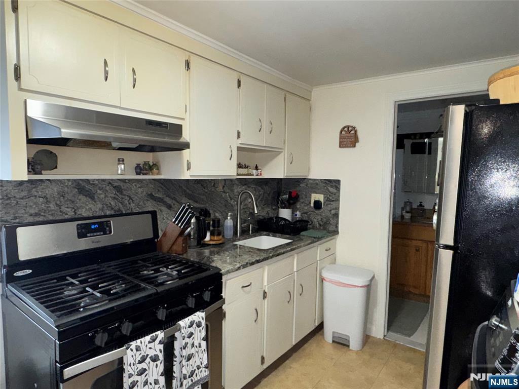542 Prospect Place Lyndhurst, NJ 07071 - Photo 4 of 7 a kitchen with stainless steel appliances a stove a sink and a refrigerator