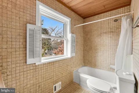 a bathroom with a toilet and bathtub
