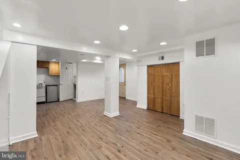 a view of empty room with wooden floor