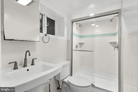 a bathroom with a sink mirror shower and toilet