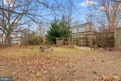 a backyard of a house with large trees and outdoor space