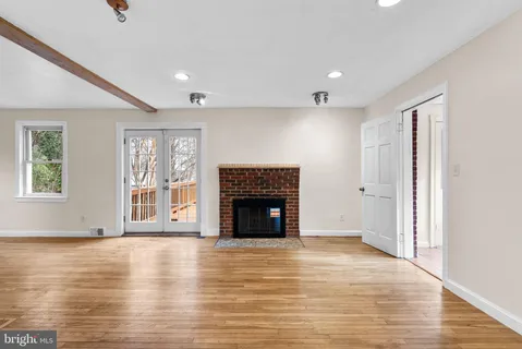 wooden floor fireplace and windows in an empty room