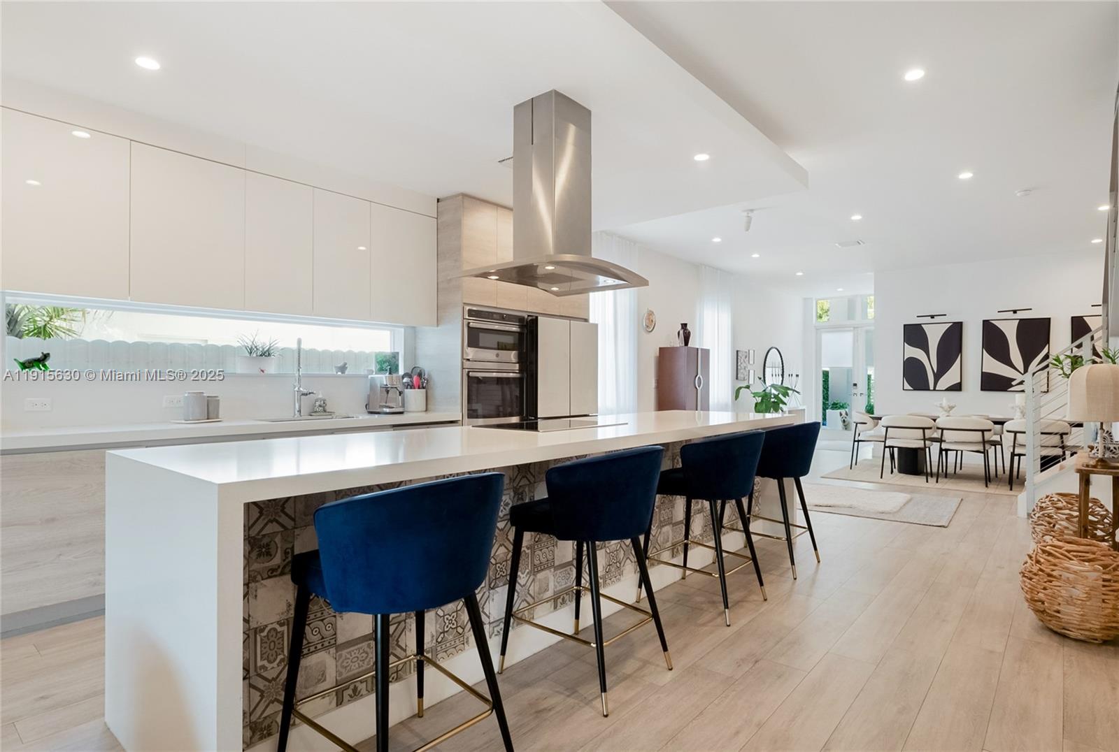 2410 Southwest 16th Avenue Miami, FL 33145 - Photo 5 of 25 a kitchen with stainless steel appliances kitchen island granite countertop a table chairs sink and cabinets