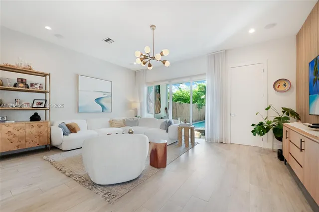 a living room with furniture and a chandelier