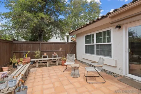 a view of a chairs and table in the back yard of the house