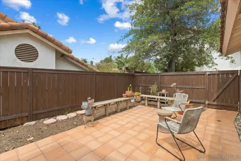 a backyard of a house with table and chairs
