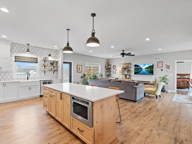 a large kitchen with stainless steel appliances granite countertop a lot of counter space and wooden floor
