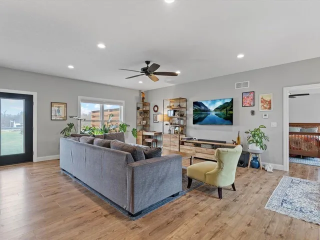 a living room with furniture flat screen tv and wooden floor