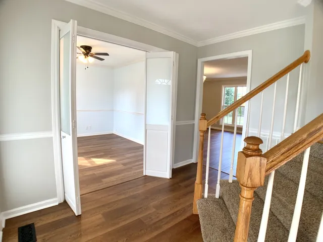 a view of a hallway with wooden floor and staircase