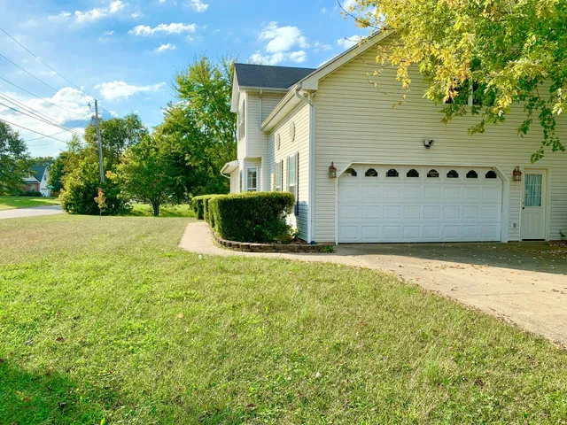 an empty room with wooden floor fireplace and windows