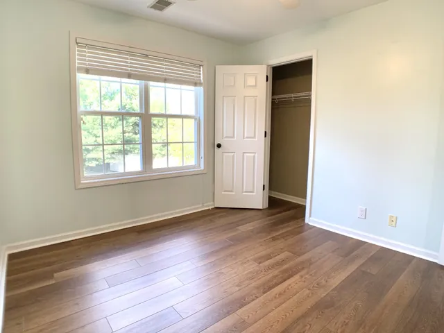 an empty room with wooden floor and windows