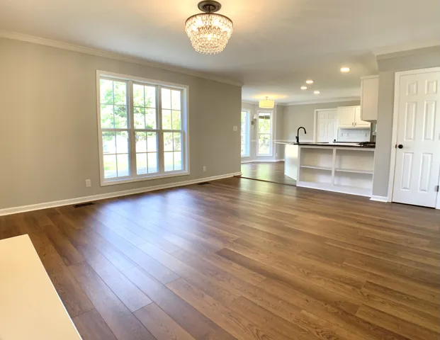 a large kitchen with stainless steel appliances granite countertop a large counter top and a wooden floors