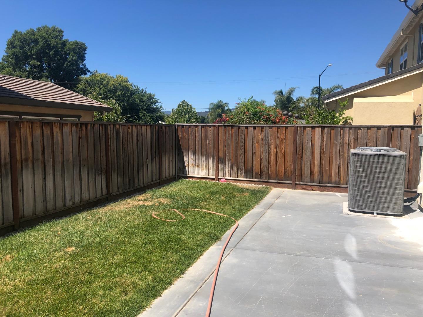 950 Puma Way Gilroy, CA 95020 - Photo 15 of 17 a view of backyard with wooden fence and trees in the background