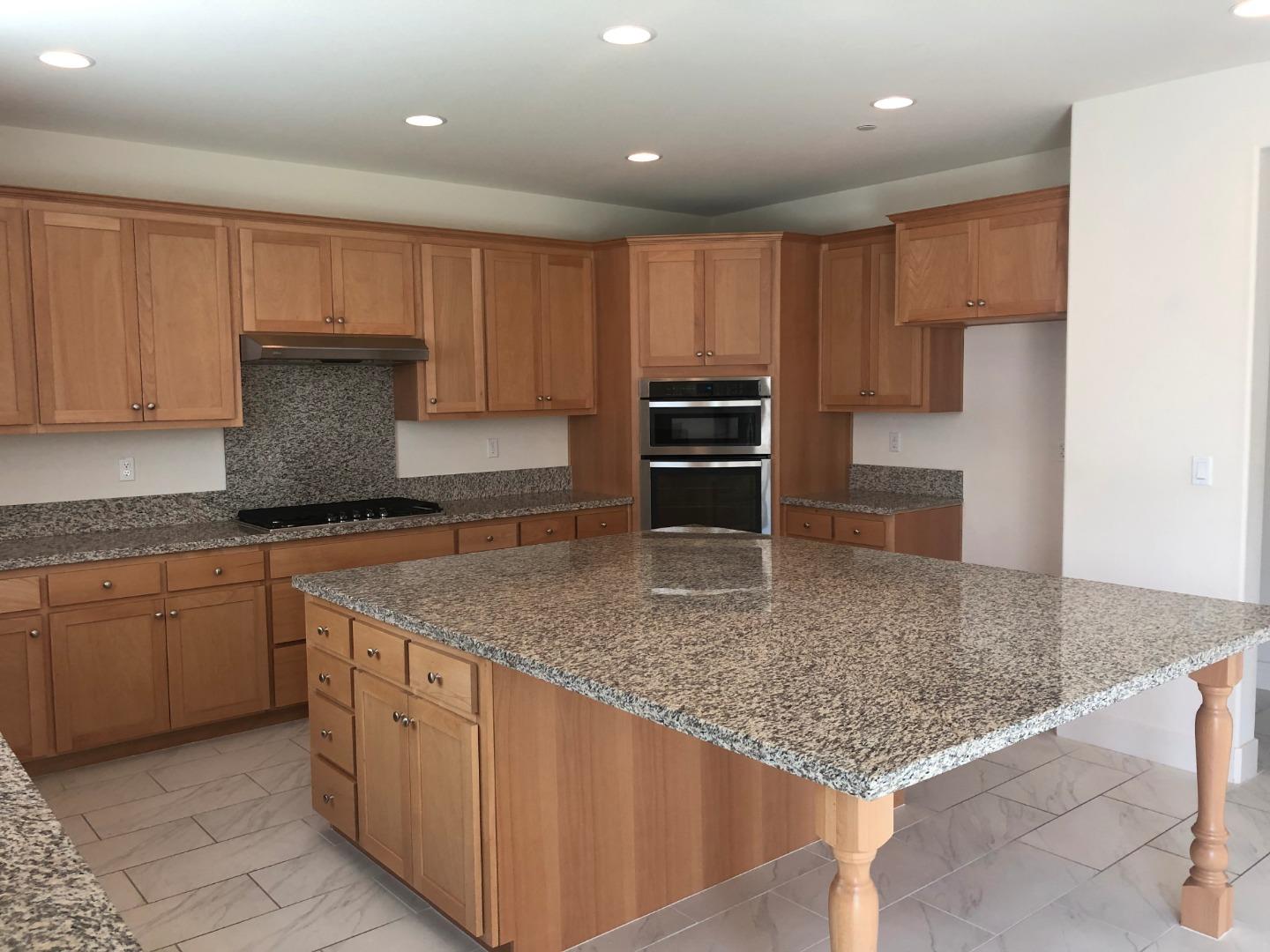 950 Puma Way Gilroy, CA 95020 - Photo 4 of 17 a kitchen with kitchen island granite countertop a sink a stove and cabinets