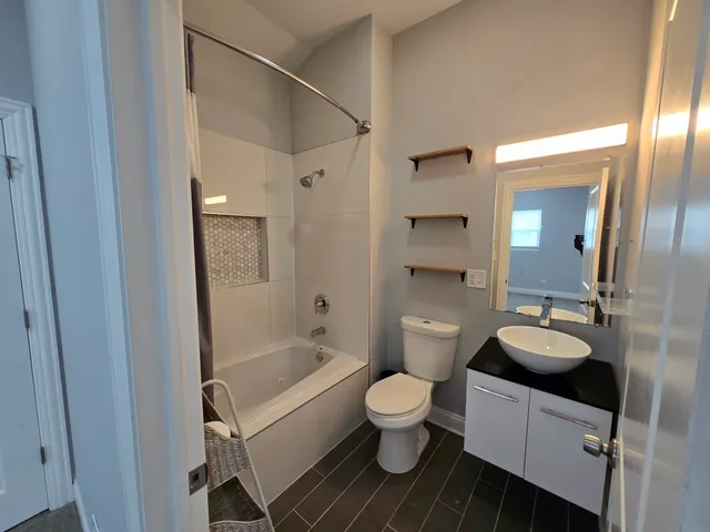 a bathroom with a granite countertop toilet sink and mirror