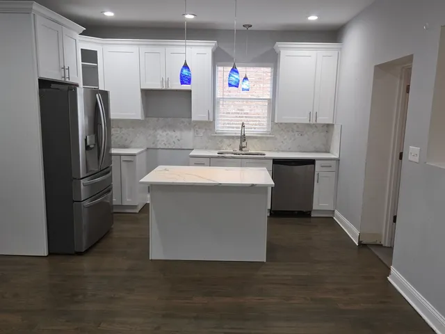 a kitchen with stainless steel appliances granite countertop a refrigerator a sink and a stove