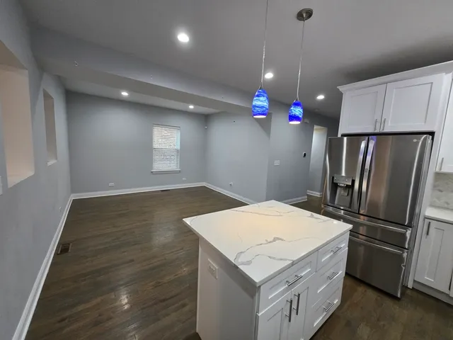 a kitchen that has a lot of cabinets and wooden floor