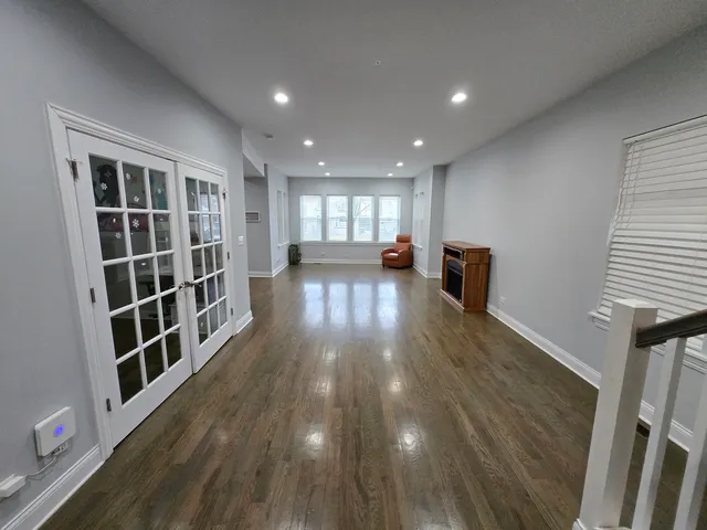 a view of empty room with wooden floor and windows