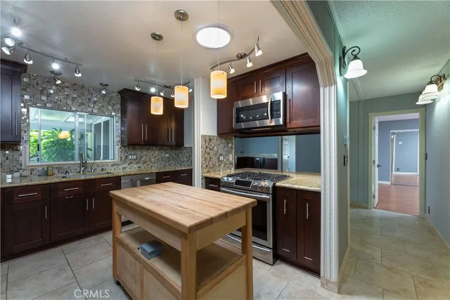 a kitchen that has a sink a stove and a oven