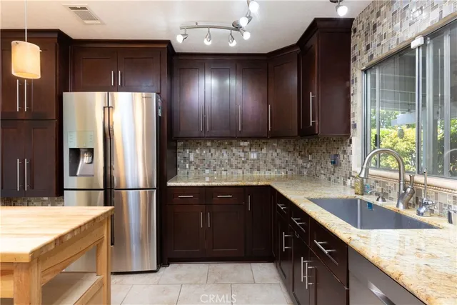 a kitchen with a sink refrigerator and cabinets