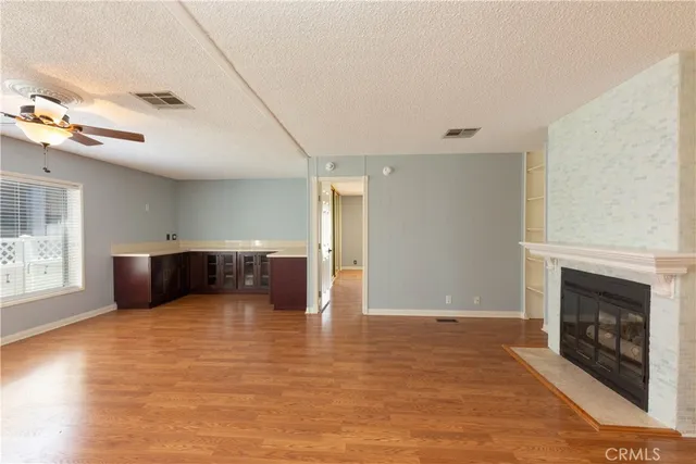 a view of a livingroom with wooden floor and a fireplace